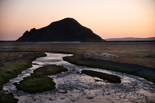 Midnight Sun over glacial water river in the north of Iceland.