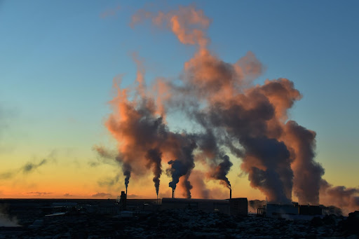 Steam rising against a sunset sky at a geothermal plant near Blue Lagoon, Iceland.