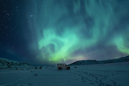Northern lights over a snowy Icelandic landscape.