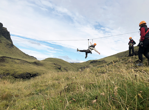 Person leaning back on zipline in Iceland. 